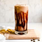 Creamy Banana Coffee Smoothie in a Tall Glass with Coffee Beans and Sliced Bananas for Food Photography