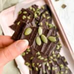 Pink Tray of Healthy No Bake Chocolate Pieces with Pumpkin Seeds on Top