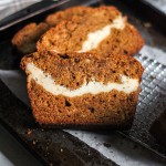 A slice of pumpkin bread with cream cheese swirl.