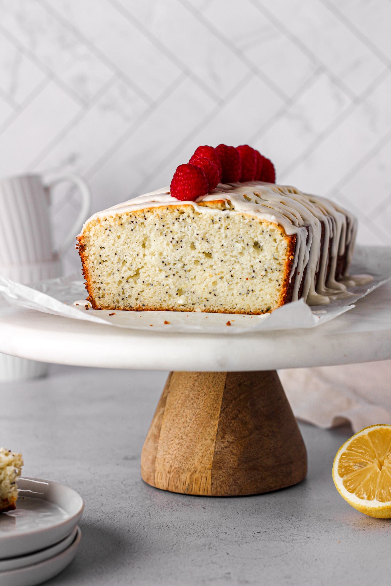 lemon pound cake with raspberries on a marble cake stand for baking blog and food photography