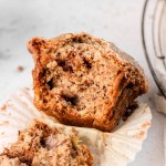 A cinnamon swirl banana muffin sitting on a muffin liner.