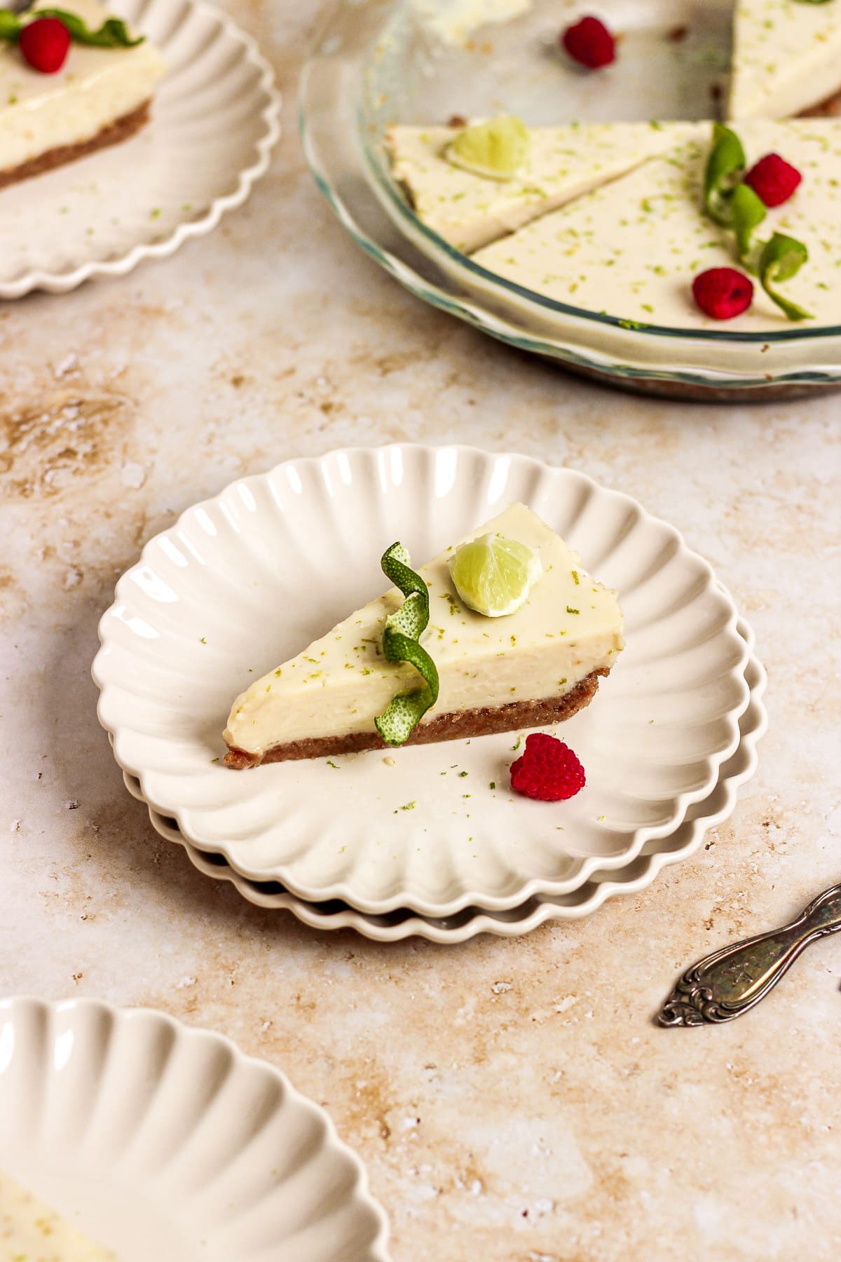key lime pie with raspberries and lime garnish