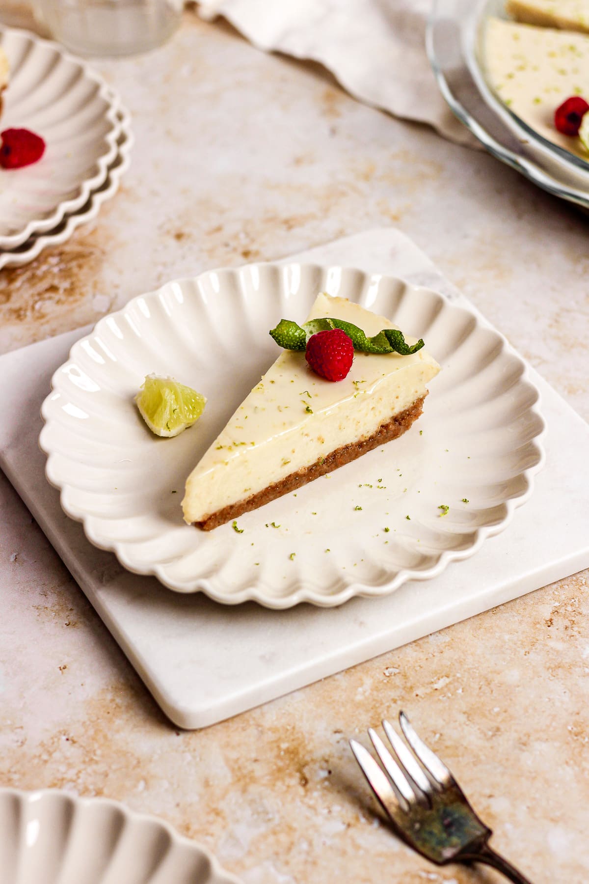 key lime pie with raspberries and lime garnish