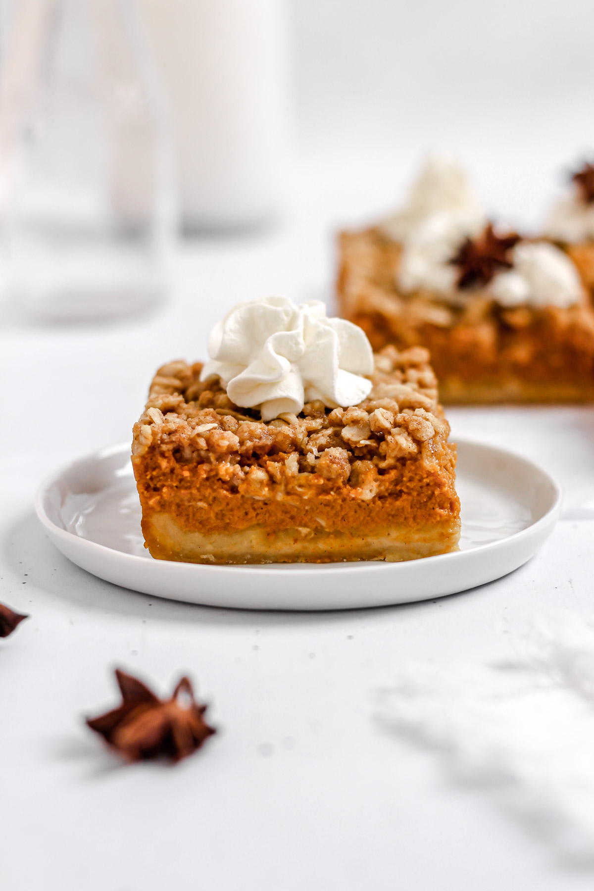 pumpkin pie bars with a shortbread crust, oatmeal crumble topping, and whipped cream