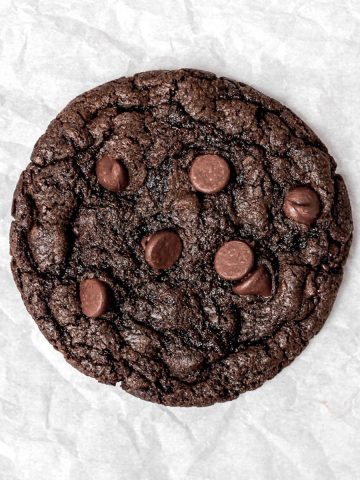 A double chocolate chip cookie on parchment paper.
