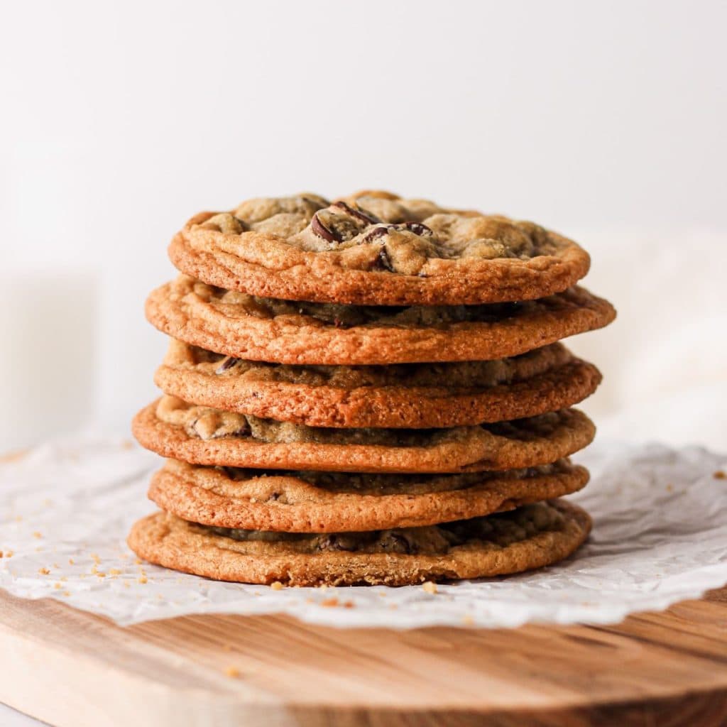 A stack of thin and chewy eggless chocolate chip cookies.