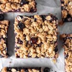 A blueberry crumble bar square with fresh blueberries and oats.