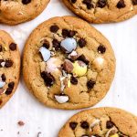 Cadbury egg chocolate chip cookies on a parchment lined baking sheet.