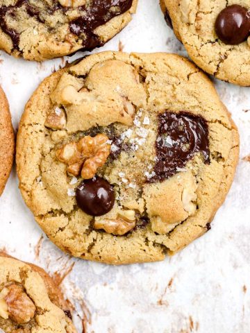 Chocolate chip walnut cookies on a parchment lined baking sheet.