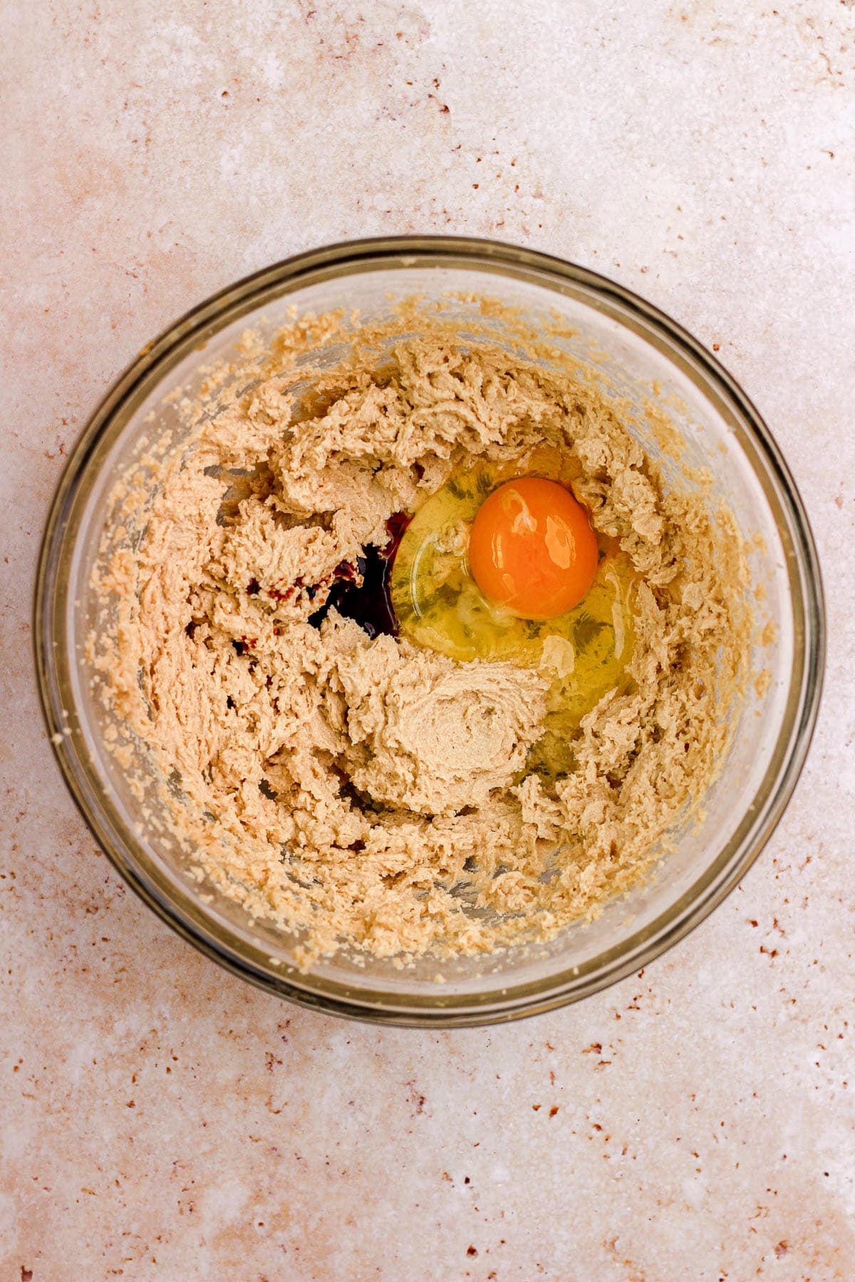 A glass bowl filled with sugar cookie dough and eggs.