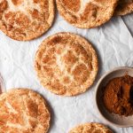 Eggless snickerdoodle cookies with cinnamon on parchment paper.