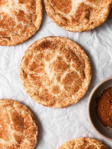 Eggless snickerdoodle cookies with cinnamon on parchment paper.