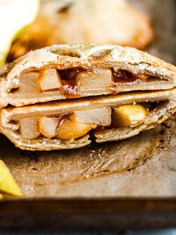 Pear hand pie cut in half revealing the juicy pear filling.