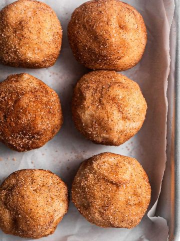 Cookie dough balls on a silver baking tray.