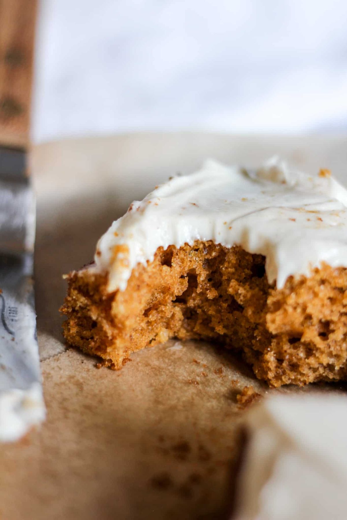 Grandmas Pumpkin Cake with Cream Cheese Frosting close up of a bite of pumpkin cake with white icing for food blog