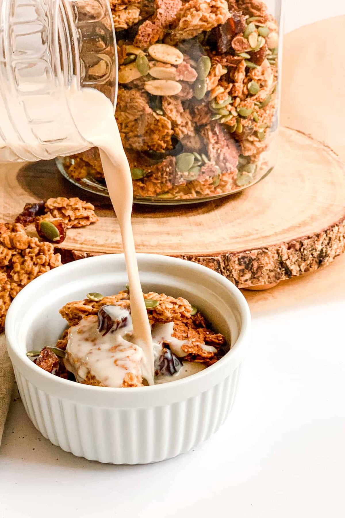 Pouring Milk into a Bowl of Healthy Crunchy Homemade Granola for Breakfast, Food Photography for Food Blog