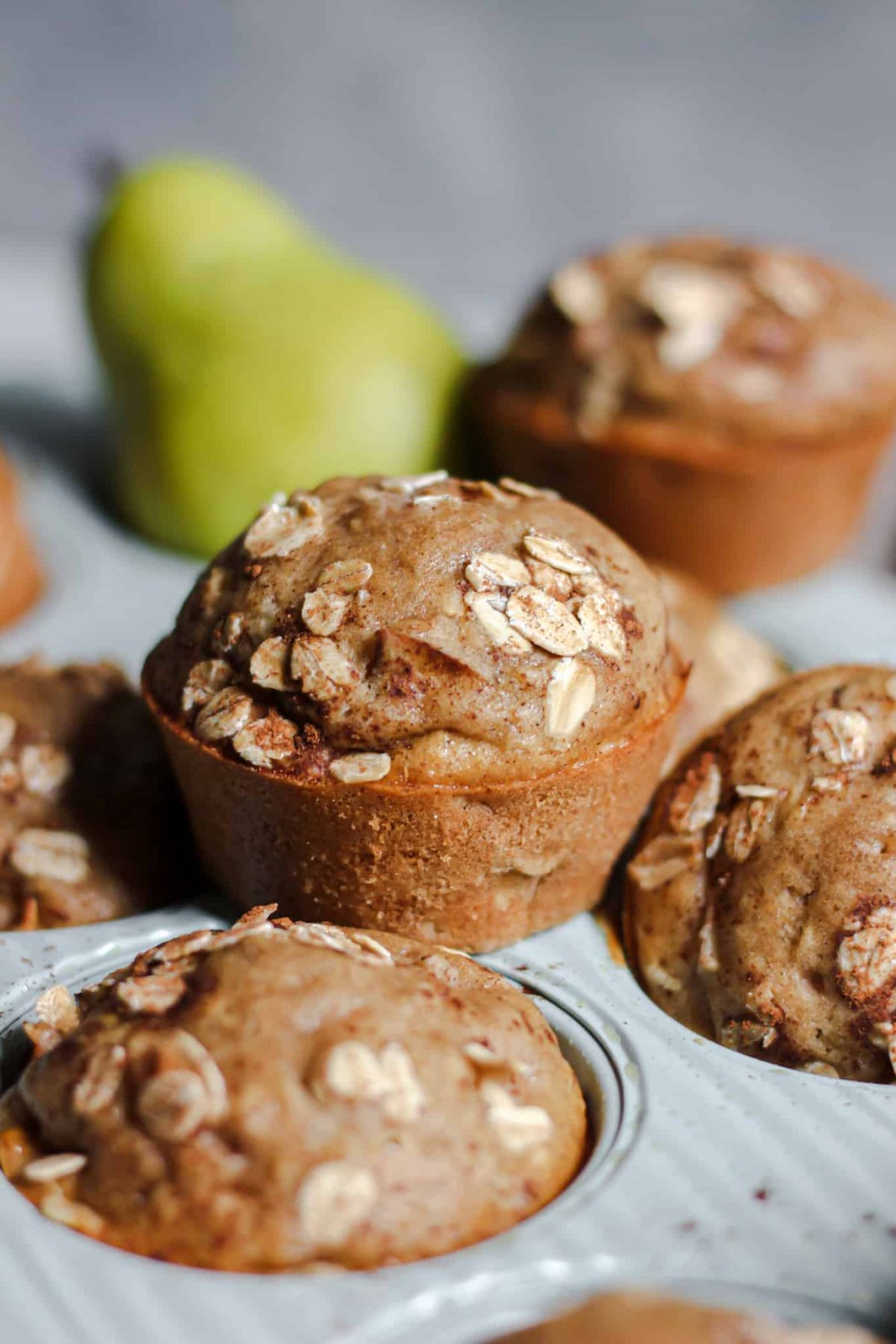 Pear Oatmeal Muffins close up shot of an oatmeal muffin surrounded by more muffins for baking photography