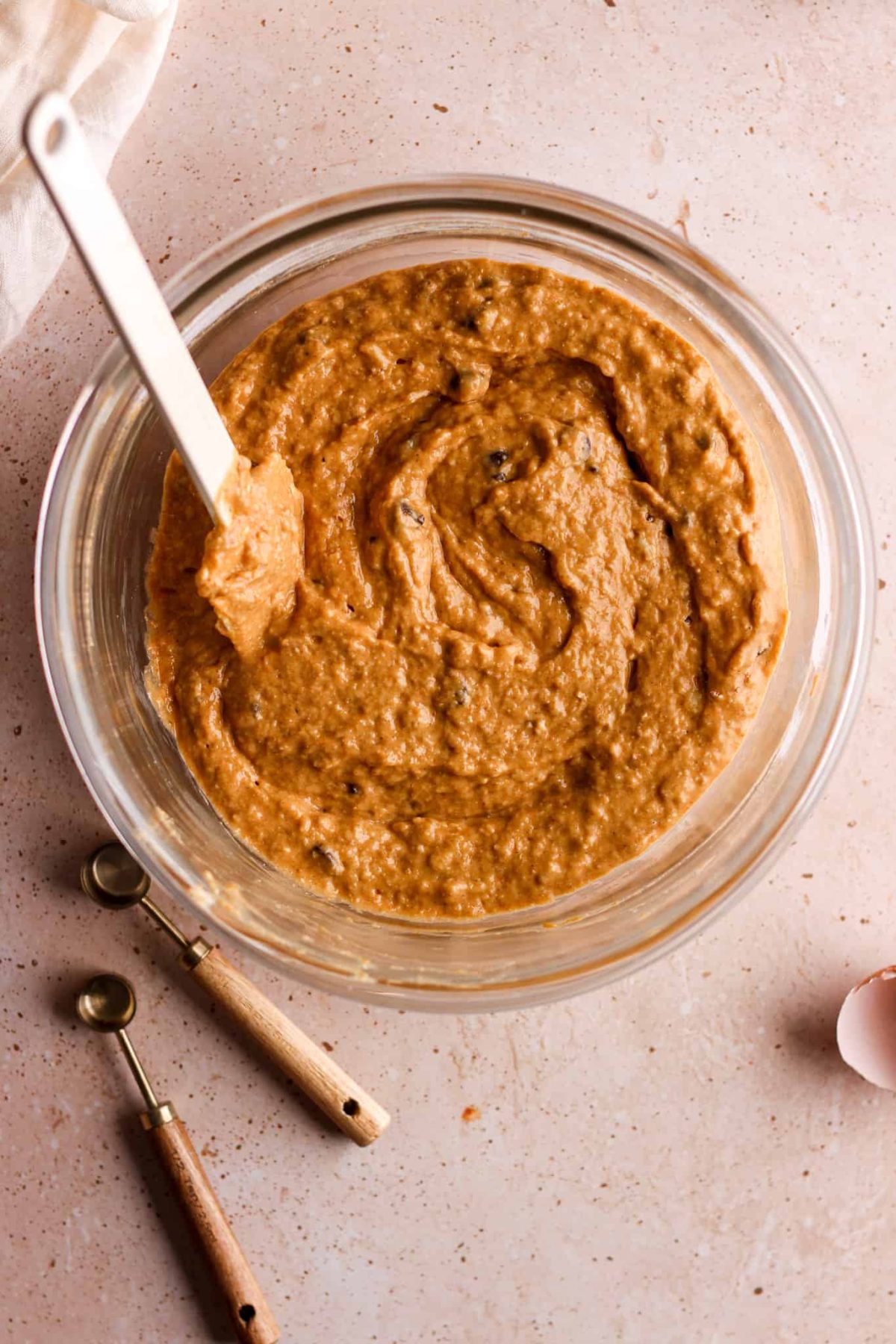 healthy pumpkin chocolate chip banana bread process shot birds eye view of glass mixing bowl with pumpkin banana bread batter fully mixed
